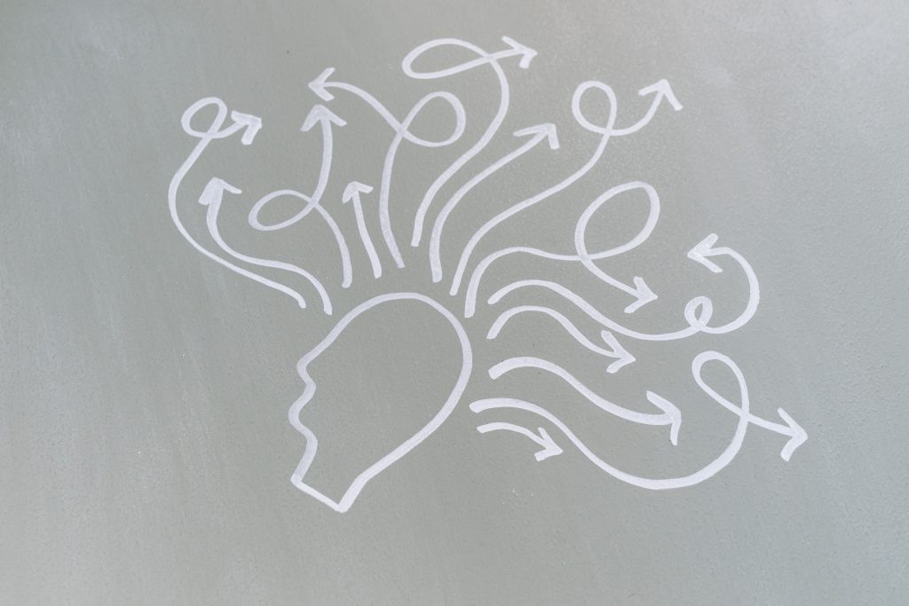 Chalk drawing of a head with swirling arrows represents mental activity and thought process.